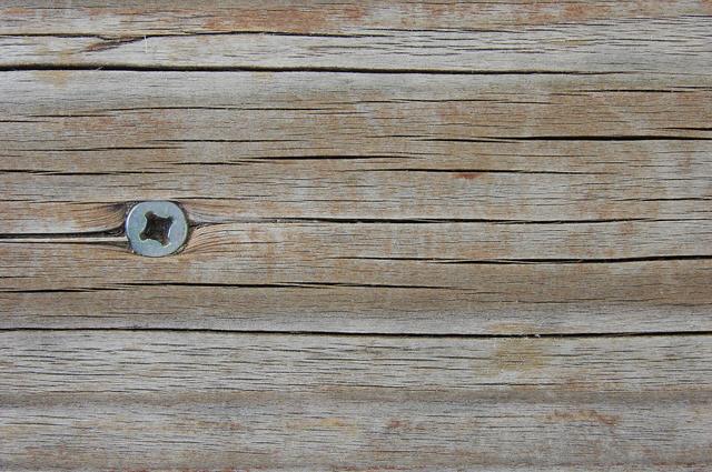Weathered grey timber boards with a screw head